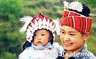 Gejia baby in mother's arm also wears its silver hat, Guizhou.