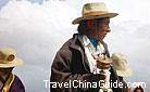 Modern clothes do not affect their traditional religion. With prayer wheel in hand, this Tibetan man is lost in his own world.