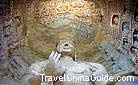 The main image in Cave 13 is an exquisitely carved cross-lagged Buddha statue wearing a jewelled crown, a bracelet and a snake-shaped necklace, Yungang Caves.