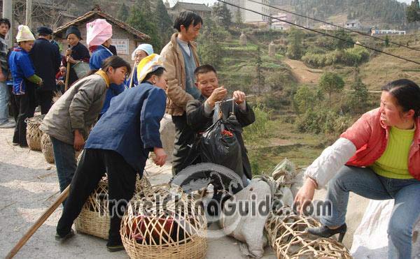 The seller is weighing the chicken.