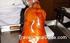 The well-roasted Beijing duck looks shining with oil in a brilliantly dark red. Few people could resist its tempting flavor of tender meat and crisp skin.