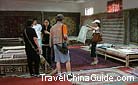 The travelers are bargaining with the seller for the silk product.