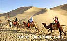 Visitors ride on the back of camels.
