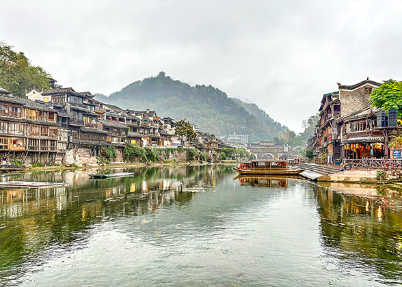 The green water and mountains, the time-honored wooden houses on stilts and the leisure life of Tujia and Miao people compose the beautiful Phoenix Ancient Town.